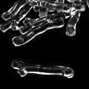 May include: A group of clear plastic tubes, some are curved and some are straight, on a black background.