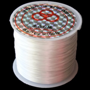 May include: A spool of white elastic string labeled "STRONG & STRETCHY" and "水色の線 ELASTIC STRING ポリウレタン 100%"