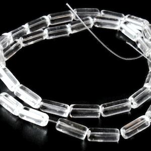 May include: A strand of clear glass beads, each bead is a rectangular prism shape.