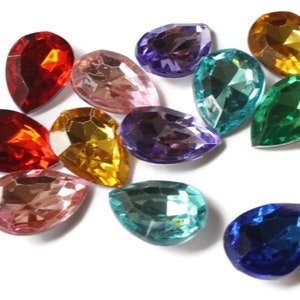 May include: Assortment of teardrop-shaped glass rhinestones in various colors, including red, pink, purple, blue, green, and gold.