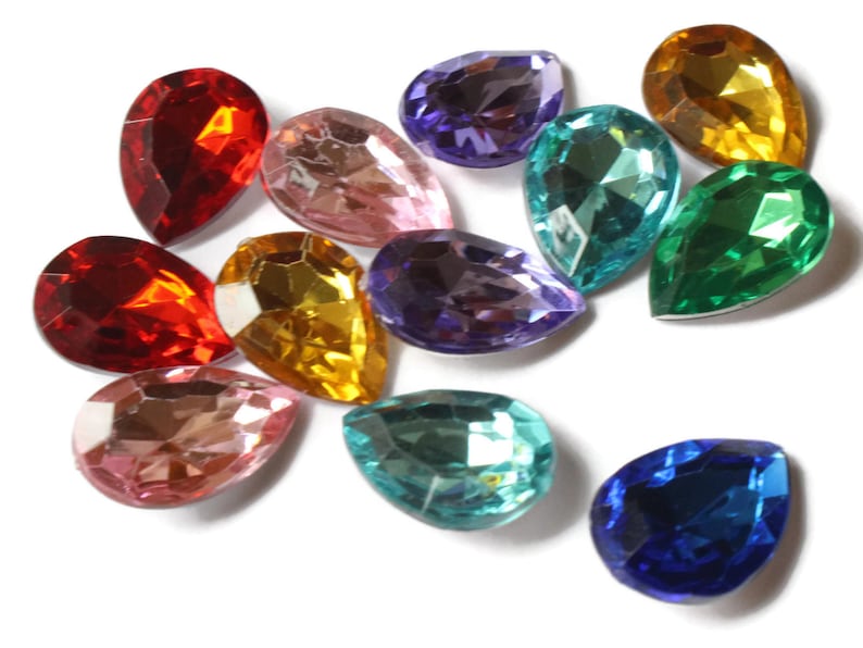 May include: Assortment of teardrop-shaped glass rhinestones in various colors, including red, pink, purple, blue, green, and gold.