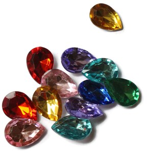 May include: Assortment of colorful teardrop-shaped glass rhinestones in various shades of red, pink, blue, green, purple, and yellow.