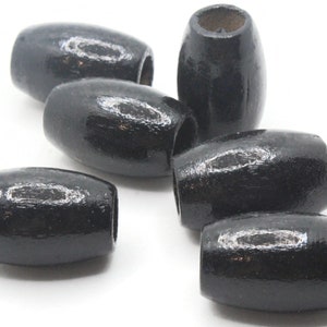 Może przedstawiać: Kolekcja czarnych drewnianych koralików z błyszczącym wykończeniem. Koraliki mają owalny kształt z otworem pośrodku, idealne do nawlekania. Koraliki są w jednolitym czarnym kolorze.