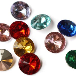 May include: Assortment of ten colorful, faceted glass gems. The gems are round and have a variety of colors, including red, blue, green, purple, and pink.