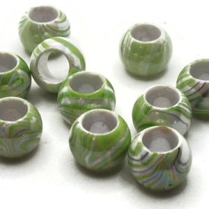 May include: A group of ten green and white swirl patterned beads. The beads are round and have a hole in the center.