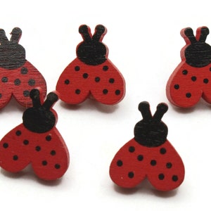 May include: Five wooden ladybug buttons with black heads and red bodies with black dots.