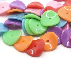 May include: A collection of colorful, teardrop-shaped buttons in various shades, including pink, purple, green, orange, and blue. Each button has a single hole for sewing. These plastic buttons are ideal for craft projects.