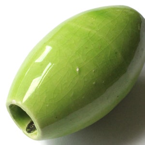 以下が含まれることがあります： 上部に穴が開いた、滑らかな緑色のオリーブ型のセラミック花瓶