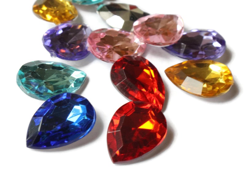 May include: Assortment of colorful teardrop-shaped glass rhinestones in various colors, including red, blue, green, purple, and yellow.