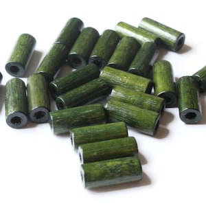 May include: A pile of green wooden beads, each with a hole in the center. The beads are cylindrical and have a slightly rough texture.