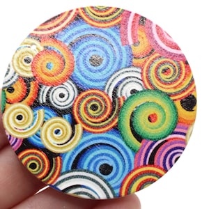 May include: A round wooden disc with a colorful pattern of concentric circles in shades of blue, green, yellow, red, and white.
