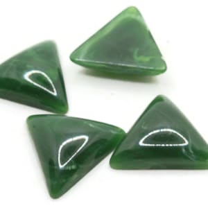Puede incluir: Cuatro cabujones de forma triangular de color verde con un patrón de mármol. Los cabujones son lisos y pulidos.