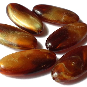 May include: Six oval-shaped beads with a brown and gold iridescent finish. The beads have a smooth, glossy surface and are perfect for jewelry making.