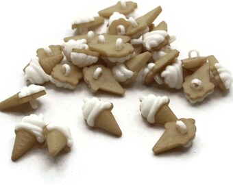 May include: A collection of small, tan ice cream cone and sandwich-shaped buttons with white frosting details. The buttons are made of plastic and have a loop on the back for sewing or crafting. The buttons are scattered on a white background.