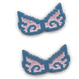 May include: Two blue and pink wing-shaped enamel pins. The pins have a pixelated design with a blue outline and a pink interior. The wings are symmetrical and have a decorative, swirling pattern.