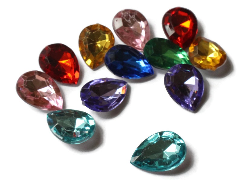 May include: Assortment of pearlescent teardrop-shaped glass rhinestones in various colors, including pink, red, yellow, green, blue, purple, and teal.