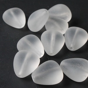 May include: A group of 10 clear frosted glass beads in a teardrop shape. The beads are smooth and have a slightly iridescent finish.