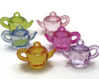 May include: Six colorful plastic teapots with a faceted design. The teapots are in shades of green, blue, pink, purple, and yellow.
