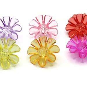 May include: Six plastic flower-shaped hair clips in various colors: purple, pink, orange, yellow, and two shades of pink.