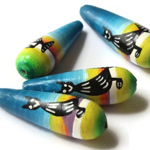 May include: Four wooden beads with a blue, green, yellow, and white painted design. Each bead features a black silhouette of a cat with white stripes.