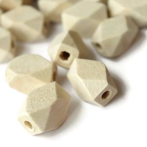 May include: A group of natural wood beads with a faceted, geometric shape. The beads have a hole in the center for stringing.