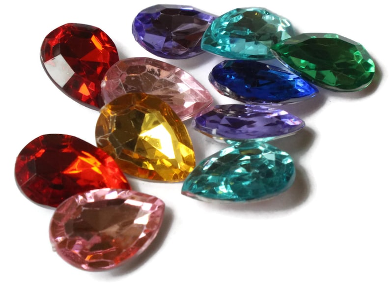 May include: Assortment of teardrop-shaped glass rhinestones in various colors, including red, pink, gold, green, blue, and purple.