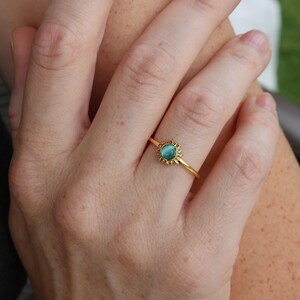 May include: A gold ring with a turquoise gemstone set in a sunburst design.