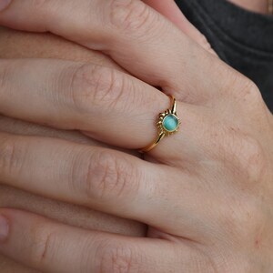 May include: A gold ring with a turquoise gemstone set in a sunburst design.
