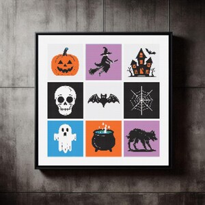 May include: A framed Halloween cross-stitch artwork. It features nine square panels, each with a different design: a pumpkin, witch, haunted house, skull, bat, spiderweb, ghost, cauldron, and a werewolf. The artwork is framed in black and is displayed on a wall.