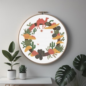Kruissteekkranspatroon met woestijndieren, kamelen, cactussen en vetplanten – uniek op de woestijn geïnspireerd ontwerp met warme bruintinten en zandgeel