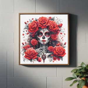 May include: A framed illustration of a woman with sugar skull makeup, wearing a crown of red roses. The background is white.