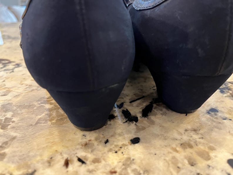 K&ouml;nnte beinhalten: Ein Paar marineblaue Keilabsatzschuhe. Die Schuhe haben eine abgerundete Spitze und ein strukturiertes Obermaterial. Der Keilabsatz ist etwa 5 cm hoch. Die Schuhe stehen auf einer hellbraunen Oberfl&auml;che.
