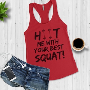 May include: Red tank top with a black graphic that says "HIIT ME WITH YOUR BEST SQUAT!" The graphic includes two small dumbbell icons.