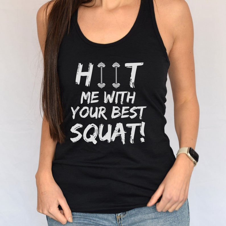 May include: Black tank top with white text that reads "HIIT ME WITH YOUR BEST SQUAT!" The text includes a dumbbell graphic.