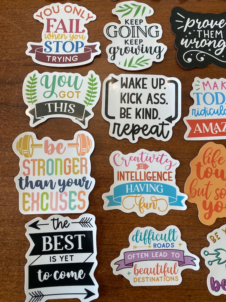 May include: A set of 12 colorful motivational stickers with positive messages. The stickers feature phrases like "You Only Fail When You Stop Trying", "Keep Going Keep Growing", "Prove Them Wrong", "You Got This", "Wake Up Kick Ass Be Kind Repeat", "Make Today Ridiculously Amazing", "Be Stronger Than Your Excuses", "Creativity Is Intelligence Having Fun", "Life Is Tough But So Are You", "The Best Is Yet To Come", "Difficult Roads Often Lead To Beautiful Destinations", and "Be Yourself".