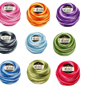 May include: Nine spools of DMC embroidery floss in various colors, including pink, orange, purple, black, blue, green, and red. Each spool is labeled with the DMC color number and the text "Perle 8 Col" and "COTON PERLE".