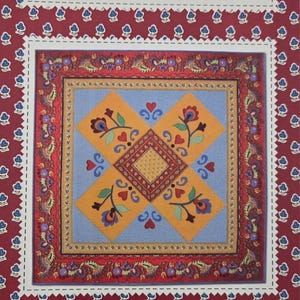 May include: A quilt pattern cover featuring a central square design with floral and heart motifs in orange, blue, and red. The cover includes the text "American Jane Patterns" and "Fleurette Quilt".