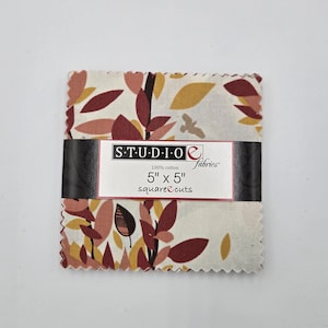 May include: A stack of Studio E Fabrics square cuts, each measuring 5" x 5". The fabric features a repeating pattern of stylized leaves in shades of burgundy, gold, and brown on a cream background. The fabric is 100% cotton.