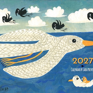 May include: A 2027 calendar by Sara Pulver featuring a large white bird with a patterned body and orange beak flying over a blue sea. Four small black birds fly in a light blue sky with white clouds. A small white bird with a chick sits below.