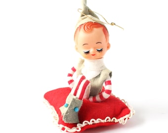 Vintage kerstkabouterkabouter op rood kussen, retro kitscherige woondecoratie