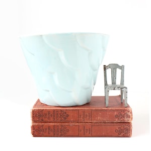 May include: A set of three ceramic mugs with a speckled, matte finish. Each mug features a different color: light blue, cream, and gray. The mugs have a simple, modern design and a comfortable handle.