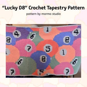 Puede incluir: Un patrón de tapiz de crochet con un diseño colorido de bolas de billar de 8. El patrón se titula "Lucky D8" y es de "mormor studio".