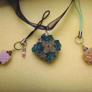 Peut inclure: Trois pendentifs perl&eacute;s avec des attaches argent&eacute;es. L'un est de forme g&eacute;om&eacute;trique avec des perles turquoise et transparentes. Un autre est un groupe de perles roses. Le troisi&egrave;me est un pendentif perl&eacute; violet clair.