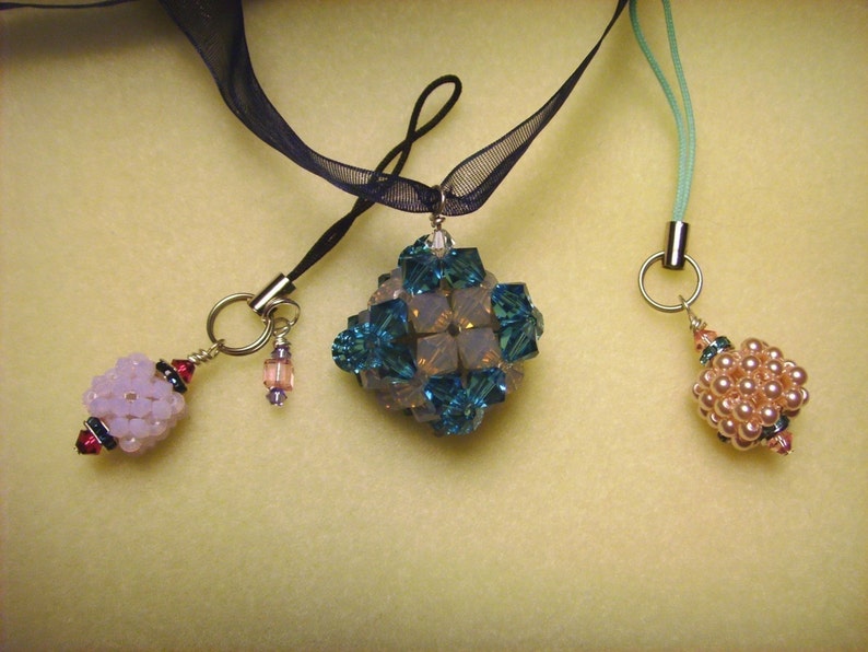 Peut inclure: Trois pendentifs perl&eacute;s avec des attaches argent&eacute;es. L'un est de forme g&eacute;om&eacute;trique avec des perles turquoise et transparentes. Un autre est un groupe de perles roses. Le troisi&egrave;me est un pendentif perl&eacute; violet clair.