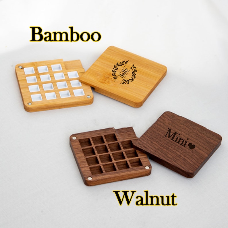 Op de afbeelding: Twee houten dozen met deksels, een van bamboe en de andere van walnoot. De bamboe doos heeft een wit deksel met een kransontwerp en de naam "Sally" erop gegraveerd. De walnootdoos heeft een deksel met het woord "Mini" en een hartje erop gegraveerd.