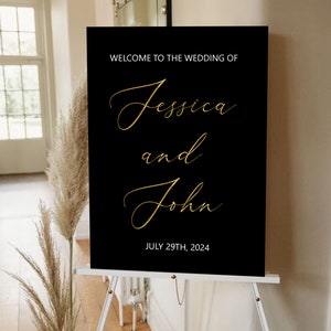 Puede incluir: Un cartel de bienvenida de boda negro con letras doradas. El cartel dice "Bienvenido a la boda de Jessica y John, 29 de julio de 2024".