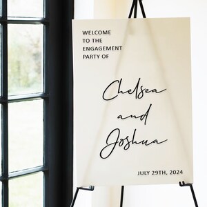 Puede incluir: Un cartel blanco con texto negro anunciando la fiesta de compromiso de Chelsea y Joshua el 29 de julio de 2024.