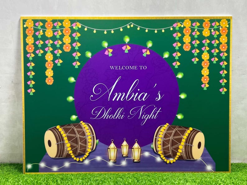 May include: A purple and green welcome sign with gold trim. The sign says "Welcome to Ambia's Dholki Night". There are two brown drums with yellow beads and white lights on the sign.
