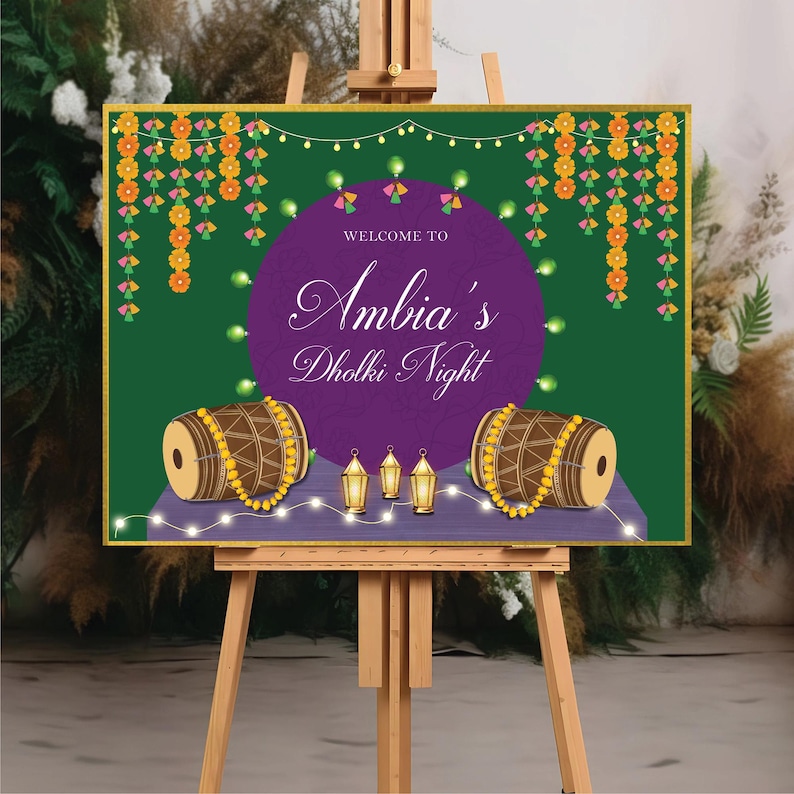 May include: Welcome to Ambia's Dholki Night sign with a purple circle background, two brown drums with yellow beads, and gold lanterns on a green background with yellow and pink floral garlands.