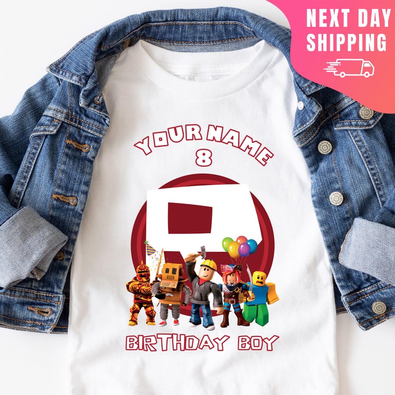 May include: White t-shirt with a red circle and the text "YOUR NAME 8" above it. Inside the circle is a red Roblox logo with a group of Roblox characters standing in front of it. The text "BIRTHDAY BOY" is below the circle.